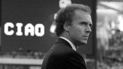 Der damalige Teamchef der deutschen Fußball-Nationalmannschaft, Franz Beckenbauer, steht im Olympiastadion am Rand des Spielfeldes. — © Martina Hellmann/dpa/Archivbild