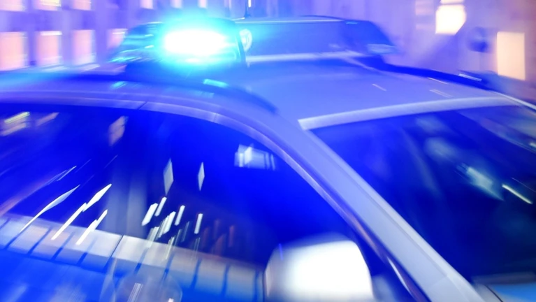 Ein Streifenwagen der Polizei steht mit eingeschaltetem Blaulicht auf der Straße. — © Carsten Rehder/dpa