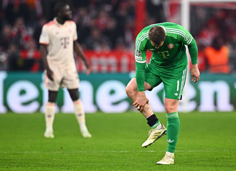 Manuel Neuer fasst sich an die verletzte Wade. — © Tom Weller/dpa