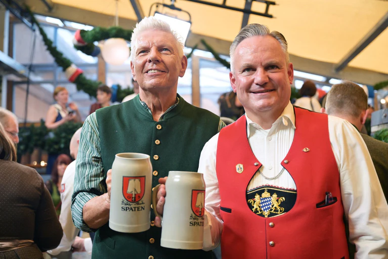 Münchens OB Dieter Reiter (l.) und Wiesnchef Christian Scharpf stoßen am ersten Oktoberfesttag miteinander an.  — © Peter Kneffel/dpa