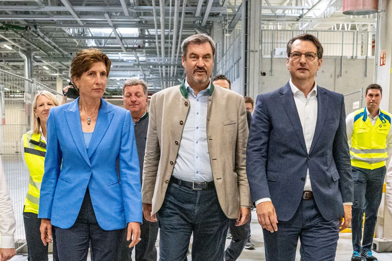 Ministerpräsident Markus Söder (Mitte) und die beiden BMW-Vorstände Ilka Horstmeier (l) und Milan Medeljkovic (r) in den Werkshallen.  — © Armin Weigel/dpa