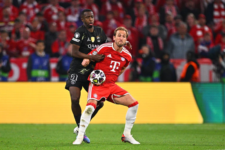 Im Zweikampf:  Willian Pacho von Paris Saint-Germain und Bayern-Torjäger Harry Kane (r). — © Tom Weller/dpa