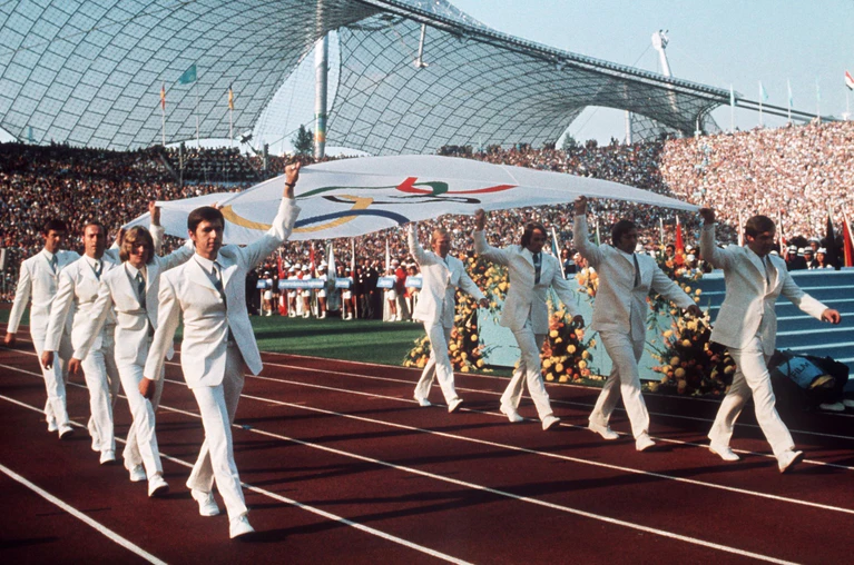 Deutsche Sportler tragen 1972 bei der Eröffnungsfeier die Olympia-Fahne in das Münchner Olympiastadion (Archivbild). — © -/Olympische_Spiele/dpa