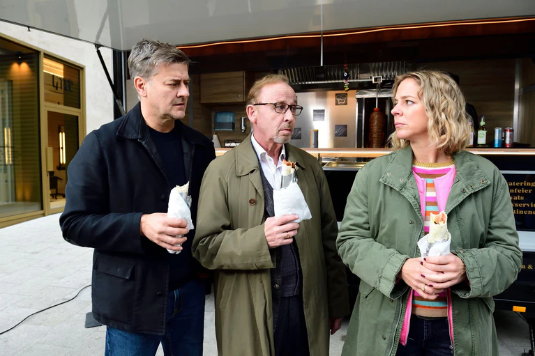 Harald Neuhauser (l, Marcus Mittermeier), Ludwig Schaller (Alexander Held) und Angelika Flierl (Bernadette Heerwagen) stehen vor einem Imbissstand. — © Jürgen Olczyk,/ZDF/dpa