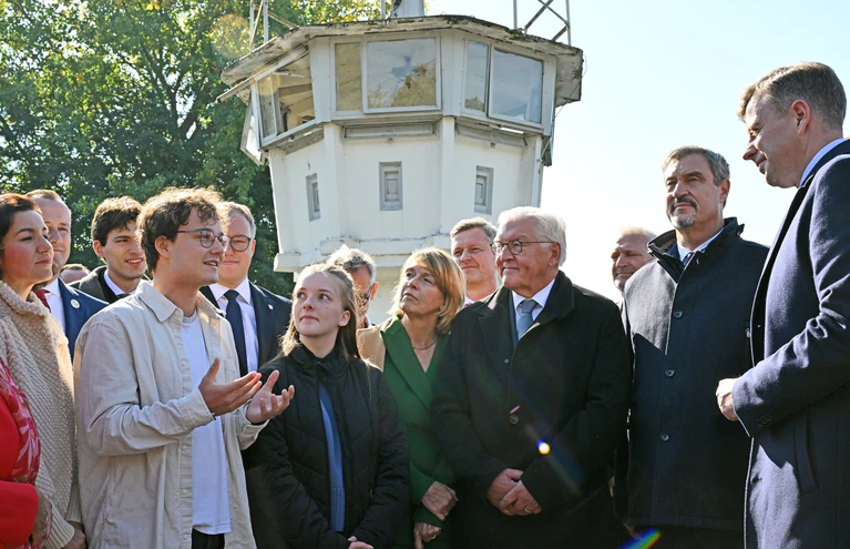 Am einstigen Grenzstreifen informiert sich der Bundespräsident (3. von rechts) über das Deutsch-Deutsche Museum Mödlareuth. — © Martin Schutt/dpa