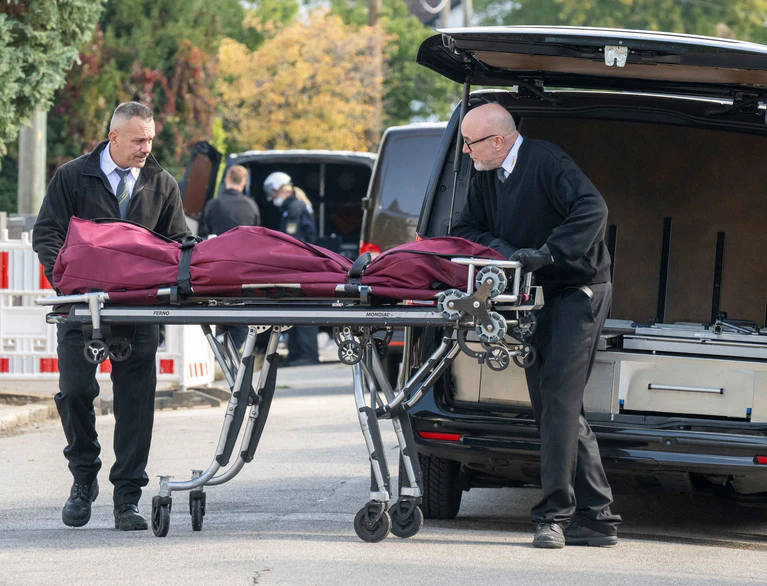 Nach dem dramatischen Einsatz mit Großbrand und Explosionen wird eine Leiche aus dem Haus geborgen.  — © Peter Kneffel/dpa