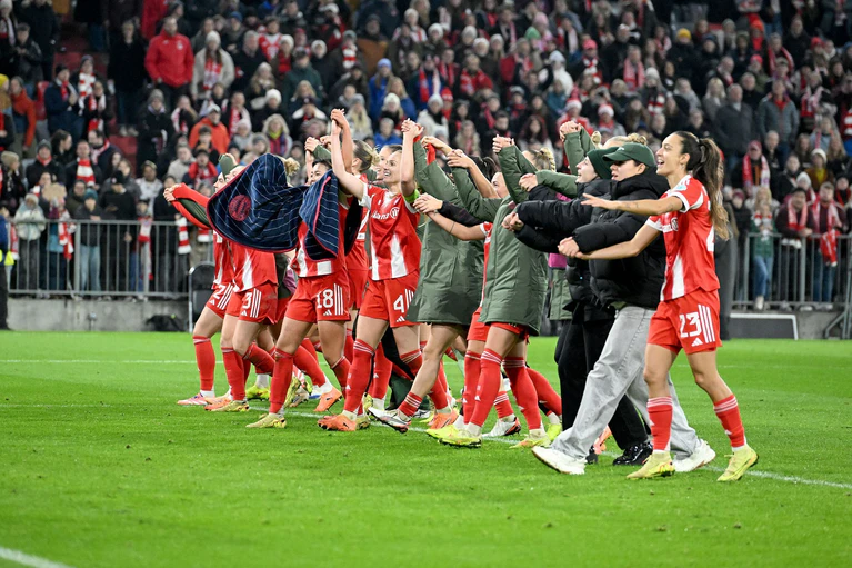Die Bayern-Fußballerinnen werden vor der Fankurve gefeiert. — © Jens Niering/dpa