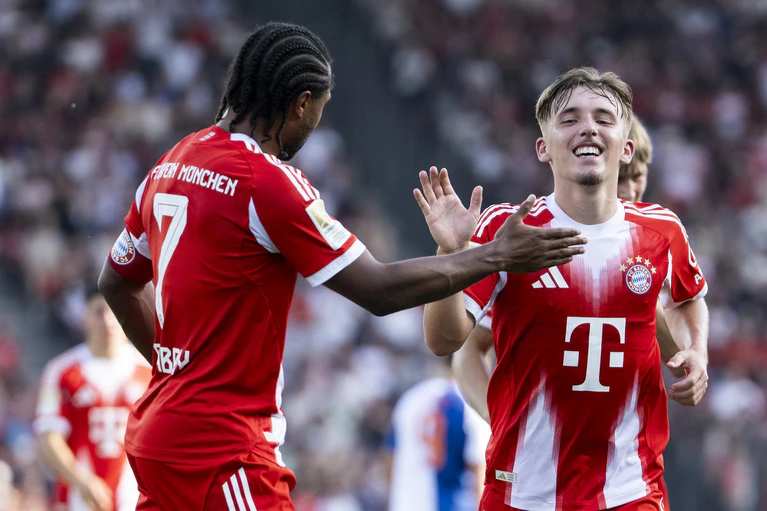 Lennart Karl (r) jubelt nach seinem wunderbaren Treffer aus der Distanz. Serge Gnabry (l) gratuliert dem Youngster. — © Ennio Leanza/KEYSTONE/dpa
