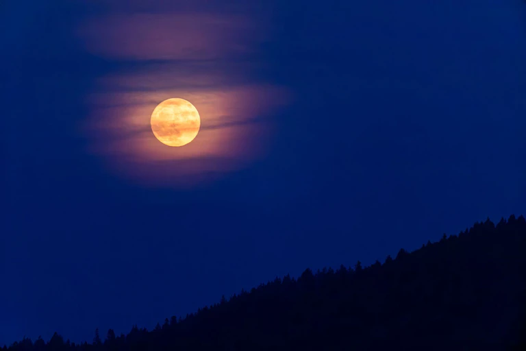 Der Rauch von den Waldbränden in Kanada lässt den Vollmond orange-rötlich erscheinen.  — © Philipp von Ditfurth/dpa