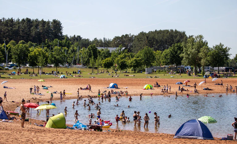 Die hohen Temperaturen laden zum Baden ein – doch durch die hohe UV-Strahlung besteht auch hohe Sonnenbrandgefahr.  — © Daniel Karmann/dpa