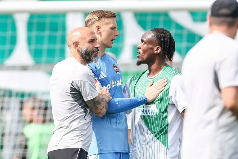 Emotionen nach dem Derby: Nürnbergs Torwart Jan Reichert und Fürths Torschütze Noel Futkeu im Disput.  — © Daniel Löb/dpa