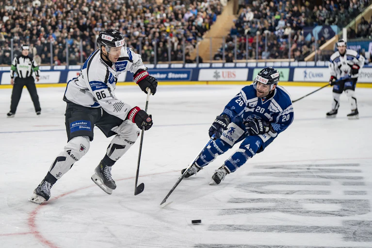 Fribourgs Julien Sprunger (l) kämpft um den Puck gegen Straubings Justin Scott. — © Til Buergy/KEYSTONE/dpa