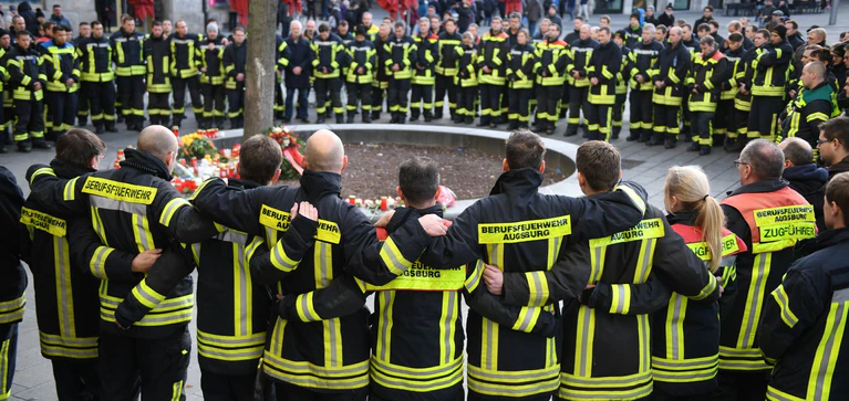 Nach der Gewalttat vom Nikolaustag 2019 trauerten die Kollegen von der Augsburger Berufsfeuerwehr um den getöteten 49-Jährigen. (Archivbild) — © Stefan Puchner/dpa