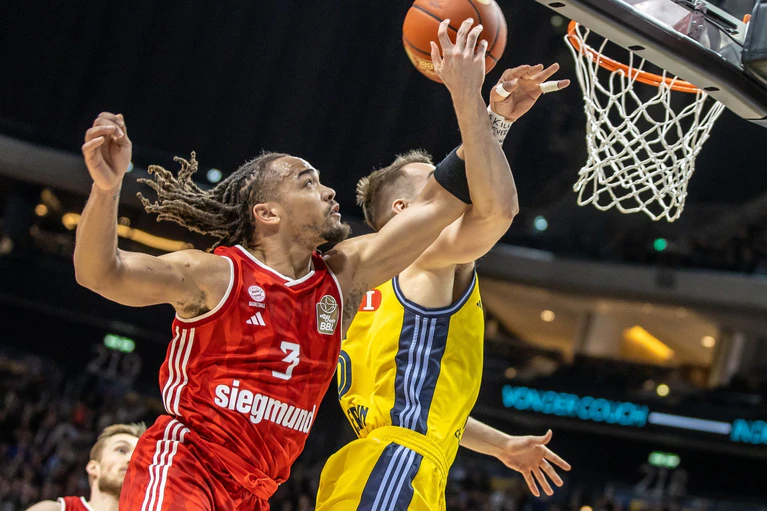 Bayerns Carsen Edwards steigt Albas Malte Delow zum Korb hoch — © Andreas Gora/dpa