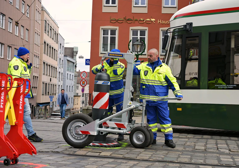 Zu den Hauptverkehrszeiten müssen Sicherheitsmitarbeiter neben dem Augsburger Christkindlesmarkt jede Stunde dutzendfach schwere Poller bewegen, damit die Straßenbahnen durchfahren können. — © Malin Wunderlich/dpa