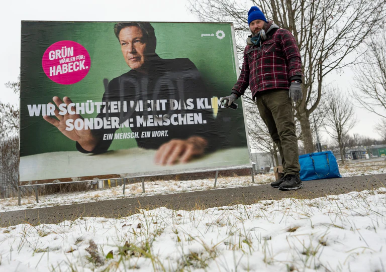 Im Auftrag der Grünen gestaltet der Künstler Bernd Imminger beschädigte Wahlplakate neu. — © Stefan Puchner/dpa