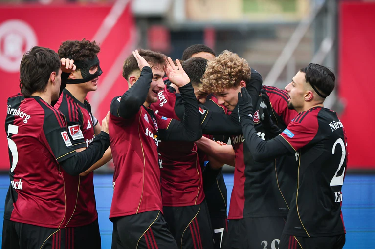 Seine Mitspieler wollen Matchwinner Piet Scobel gar nicht mehr loslassen. — © Daniel Karmann/dpa