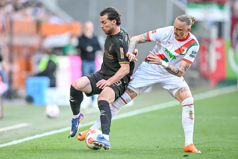 Augsburg Marius Wolf (r) nimmt dem Gladbacher Joe Scally den Ball ab. — © Harry Langer/dpa