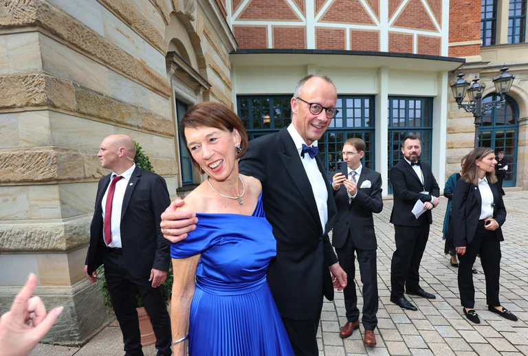 Das Ehepaar Merz vor dem Bayreuther Festspielhaus.  — © Karl-Josef Hildenbrand/dpa