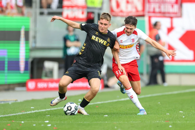 Köln-Neuzugang Isak Johannesson kämpft gegen Regensburg Leo Mätzler um den Ball. — © Daniel Löb/dpa