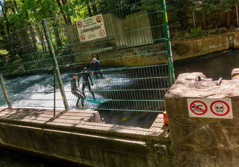 Surfer nutzen inzwischen eine andere Welle weiter unterhalb der gesperrten Welle.  — © Peter Kneffel/dpa