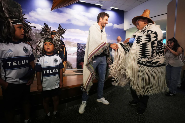 Vom Musqueam-Häuptling Wayne Sparrow bekam Müller einen Umhang geschenkt. — © Darryl Dyck/The Canadian Press/AP/dpa