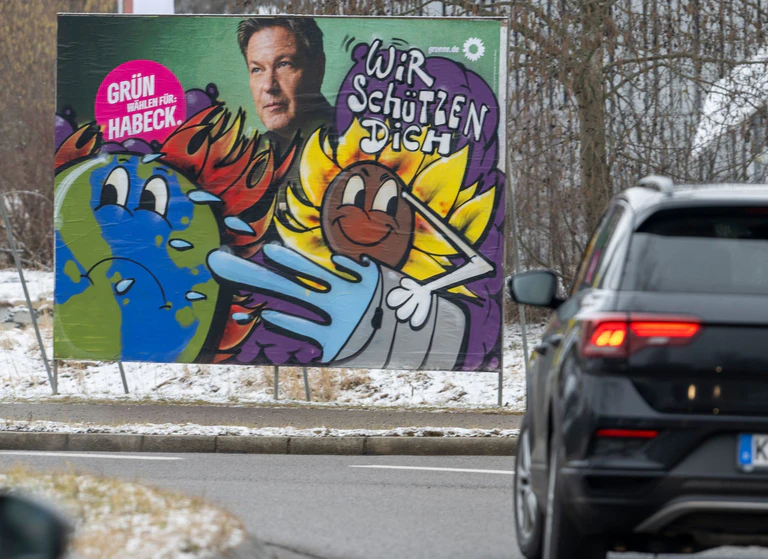Im Auftrag der Grünen werden im Allgäu beschädigte Wahlplakate von einem Künstler neu gestaltet. — © Stefan Puchner/dpa