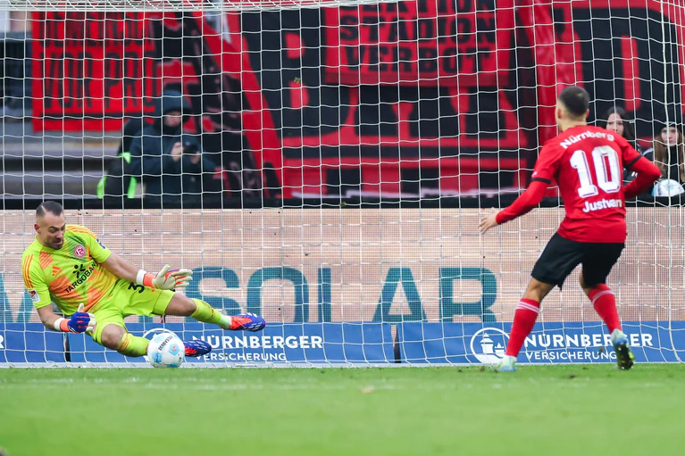 Die Schlüsselszene: Julian Justvan (r) verpasst es, beim Elfmeter auf 2:0 für Nürnberg zu erhöhen. — © Daniel Karmann/dpa