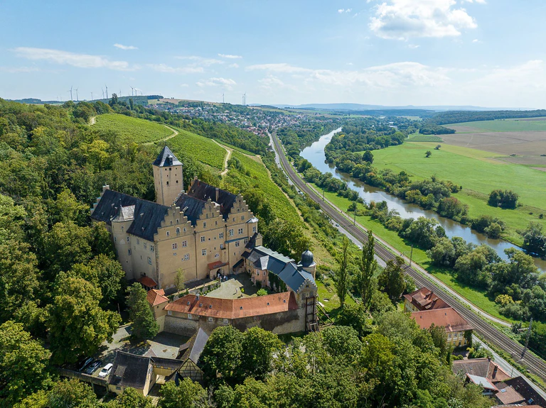 Sommerlicher Blick auf Schloss Mainberg bei Schweinfurt (Luftaufnahme mit einer Drohne). Die Gemeinde Schonungen in der Nähe von Schweinfurt sucht einen neuen Besitzer für das Schloss Mainberg, in dem Gunter Sachs geboren wurde. — © -/DSK Deutsche Stadt- und Grundstücksentwicklungsgesellschaft mbH/dpa
