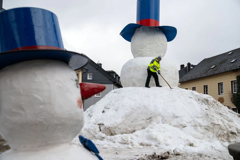 Die Handgriffe zum Bau des XXL-Schneemanns «Jakob» sitzen. — © Pia Bayer/dpa