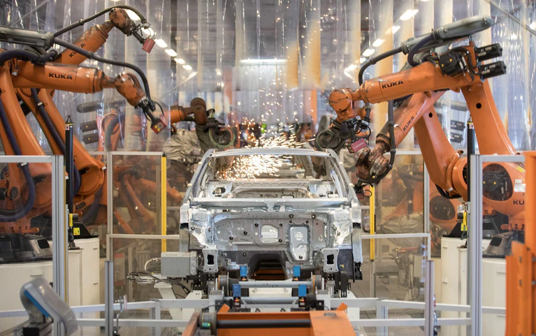 Teile eines VW Passat werden im Karosseriewerk von VW von Kuka-Robotern zusammengefügt. Der Augsburger Roboterhersteller plant den Abbau von 400 Stellen am Unternehmenssitz, insbesondere weil die Nachfrage aus der Autobranche schwach ist. (Archivbild) — © Jörg Sarbach/dpa