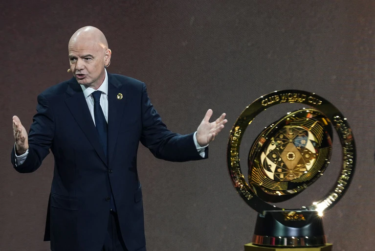 FIFA-Präsident Gianni Infantino bei der Auslosung mit der WM-Trophäe. — © Rebecca Blackwell/AP/dpa
