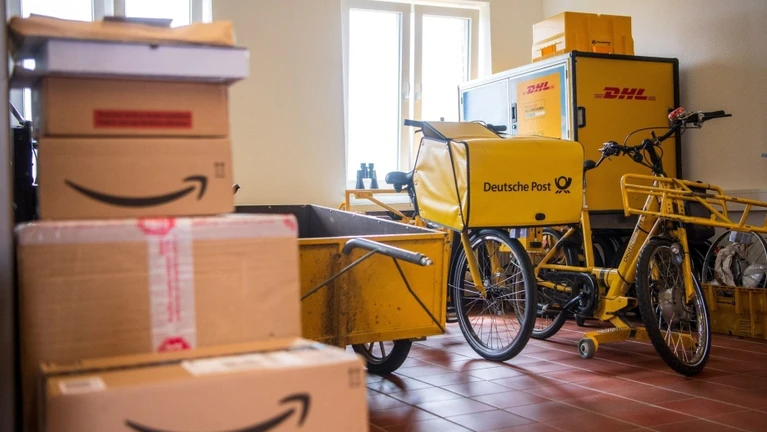 Pakete stapeln sich in einer Filiale der Deutschen Post. — © Sina Schuldt/dpa/Symbolbild