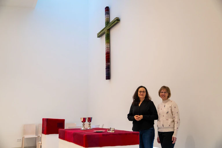 Pfarrerin Stefanie Lauterbach (l) und Prädikantin Eva-Maria Mauerer stehen am Altar im Innenraum der neuen Kirche. — © Pia Bayer/dpa