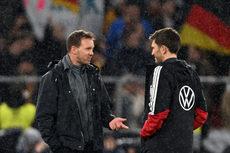 Bundestrainer Nagelsmann (l) bespricht sich mit seinem Assistenten Benjamin Glück. (Archivbild) — © Federico Gambarini/dpa