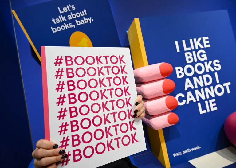 TikTok ist für Lesebegeisterte eine beliebte Plattform - bald könnten es dort immer mehr Buchshops geben.  — © Arne Dedert/dpa