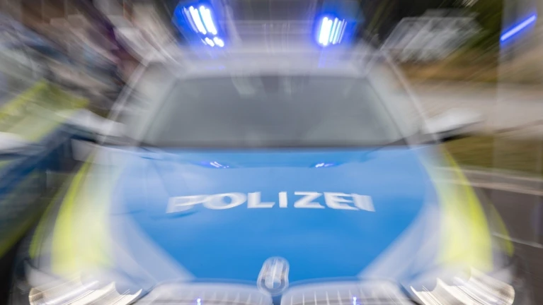 Ein Streifenwagen der Polizei mit eingeschaltetem Blaulicht. — © Daniel Karmann/dpa/Symbolbild