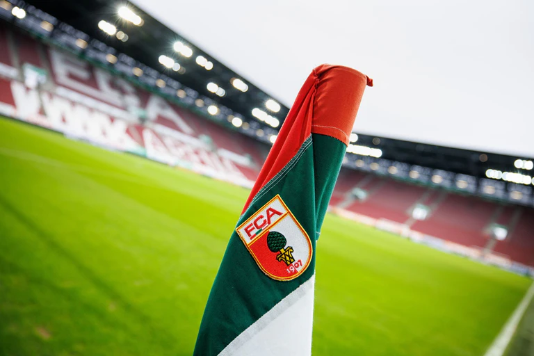 Eine Fahne des FC Augsburg steht in der WWK Arena. (Archivfoto) — © Matthias Balk/dpa