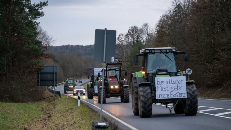 Eine Kolonne von Schleppern fährt auf der Bundesstraße 303 entlang nach Burgpreppach im Landkreis Haßberge. — © Pia Bayer/dpa