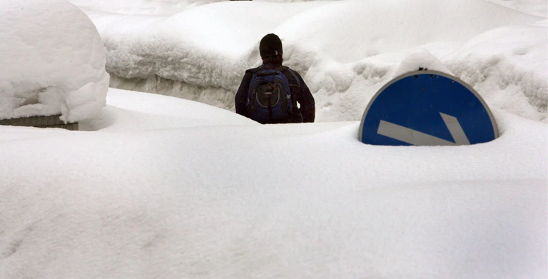 Ein Passant lief am 9. Februar 2006 in Zwiesel durch die Schneemassen. (Archivbild) — © Frank Leonhardt/dpa