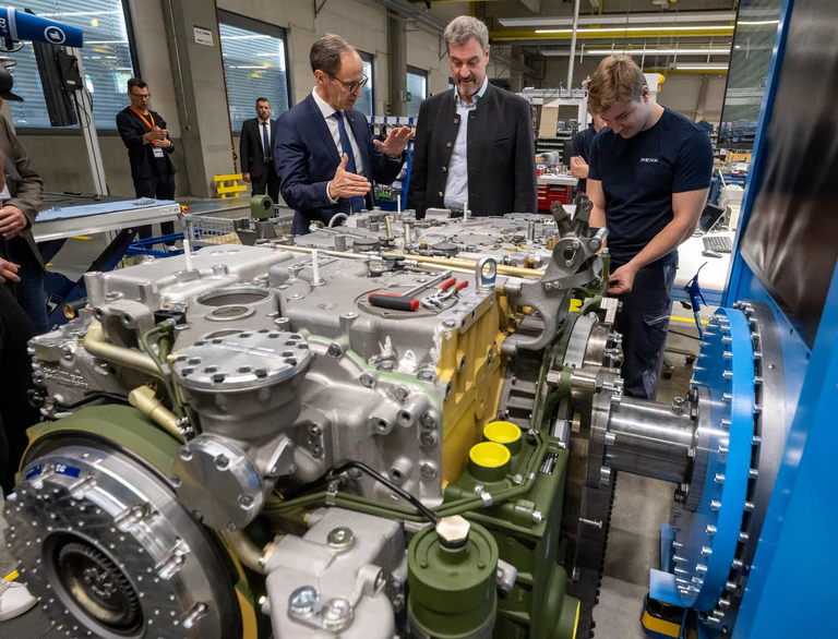 Vorstandschef Alexander Sagel stellt Bayerns Ministerpräsident Markus Söder (CSU) die neue modulare Produktion des Panzergetriebeherstellers Renk vor. — © Peter Kneffel/dpa