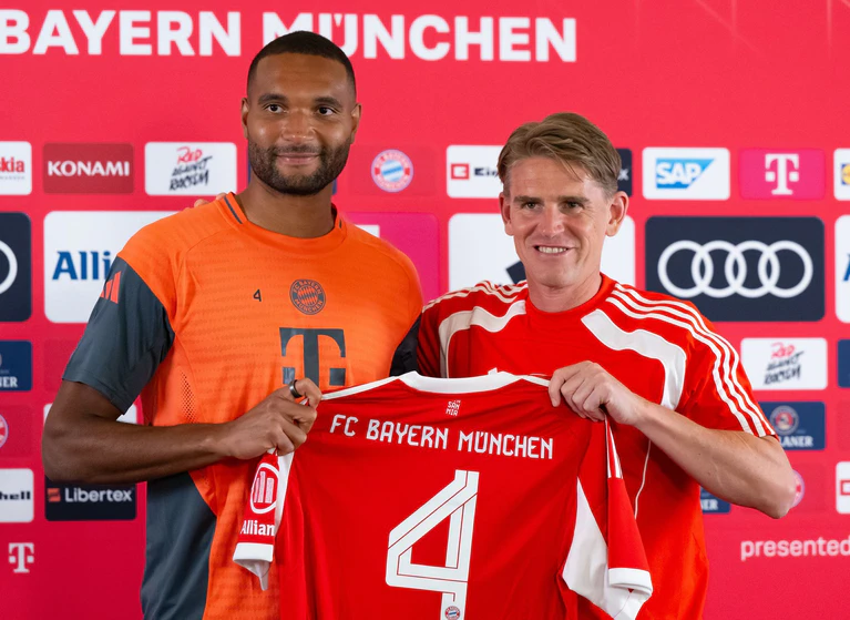 Jonathan Tah (l) und Sportdirektor Christoph Freund. Der Nationalspieler wird beim FC Bayern im Trikot mit der Nummer vier auflaufen. — © Sven Hoppe/dpa