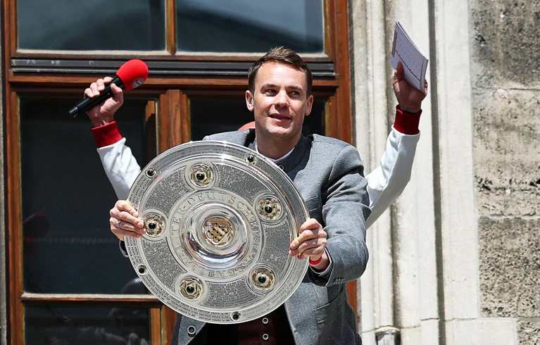 Ein gewohntes Bild: Manuel Neuer mit der Meisterschale auf dem Münchner Rathausbalkon. (Archivbild) — © Daniel Löb/dpa