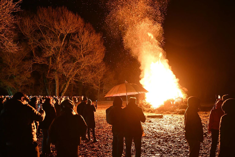 Hunderte Besucher schauen sich das Funkenfeuer an, das am Abend am Ufer des Bodensees am Malereck angezündet wurde. — © Felix Kästle/dpa