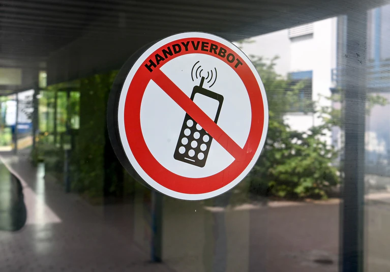Die Handynutzung an Bayerns Schulen wird wieder verschärft. Vor der achten Klasse sind Handys und Smartphones bald wieder generell verboten. (Symbolbild) — © Jens Kalaene/dpa