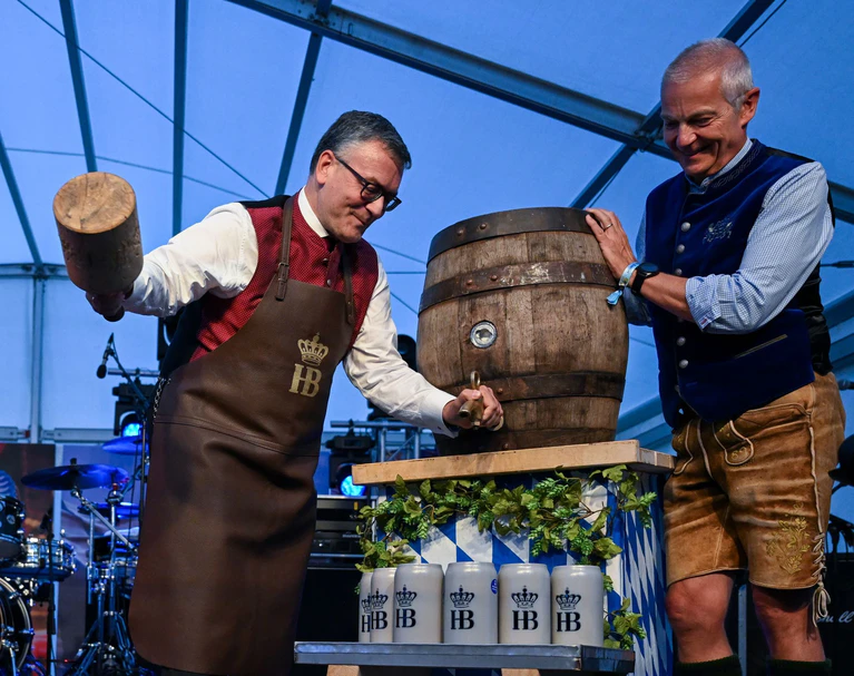 Drei kraftvolle Schläge durch Staatskanzleichef Florian Herrmann (CSU) - dann floss das Oktoberfestbier — © Soeren Stache/dpa