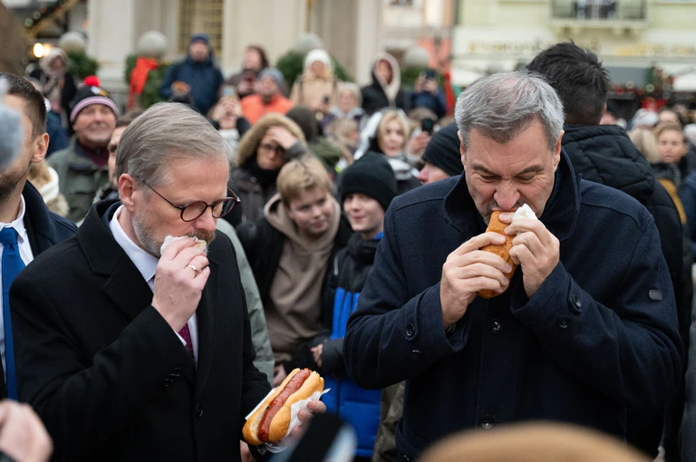 Bei einem Abstecher auf den Prager Weihnachtsmarkt gönnte Söder sich eine Bratwurst.  — © Magdalena Henkel/dpa