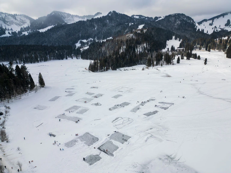 Der Spitzingsee in Oberbayern ist übersät mit Eishockey-Feldern, die Einheimische und Touristen freigeschippt haben. — © Peter Kneffel/dpa
