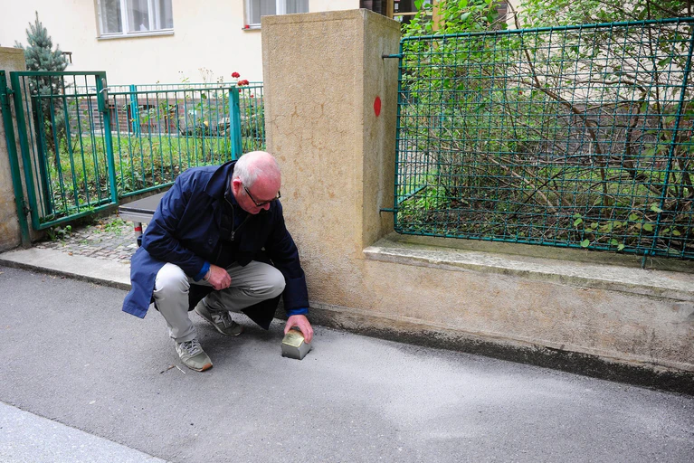 Gregory Tigrid hält den Stolperstein für seinen Vater Pavel Tigrid. In Prag erinnert vor dem Haus Kouřimská 5 ein neuer Stolperstein an den tschechischen Schriftsteller und Ex-Kulturminister Pavel Tigrid (1917-2003).  — © Michael Heitmann/dpa