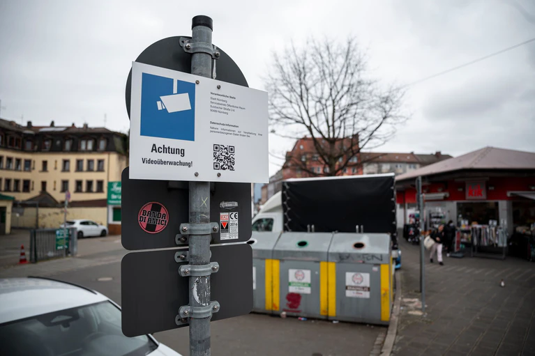 Schilder weisen auf die Videoüberwachung an den Glascontainern in der Nürnberger Südstadt hin. Dabei handelt es sich um ein Pilotprojekt.  — © Daniel Vogl/dpa